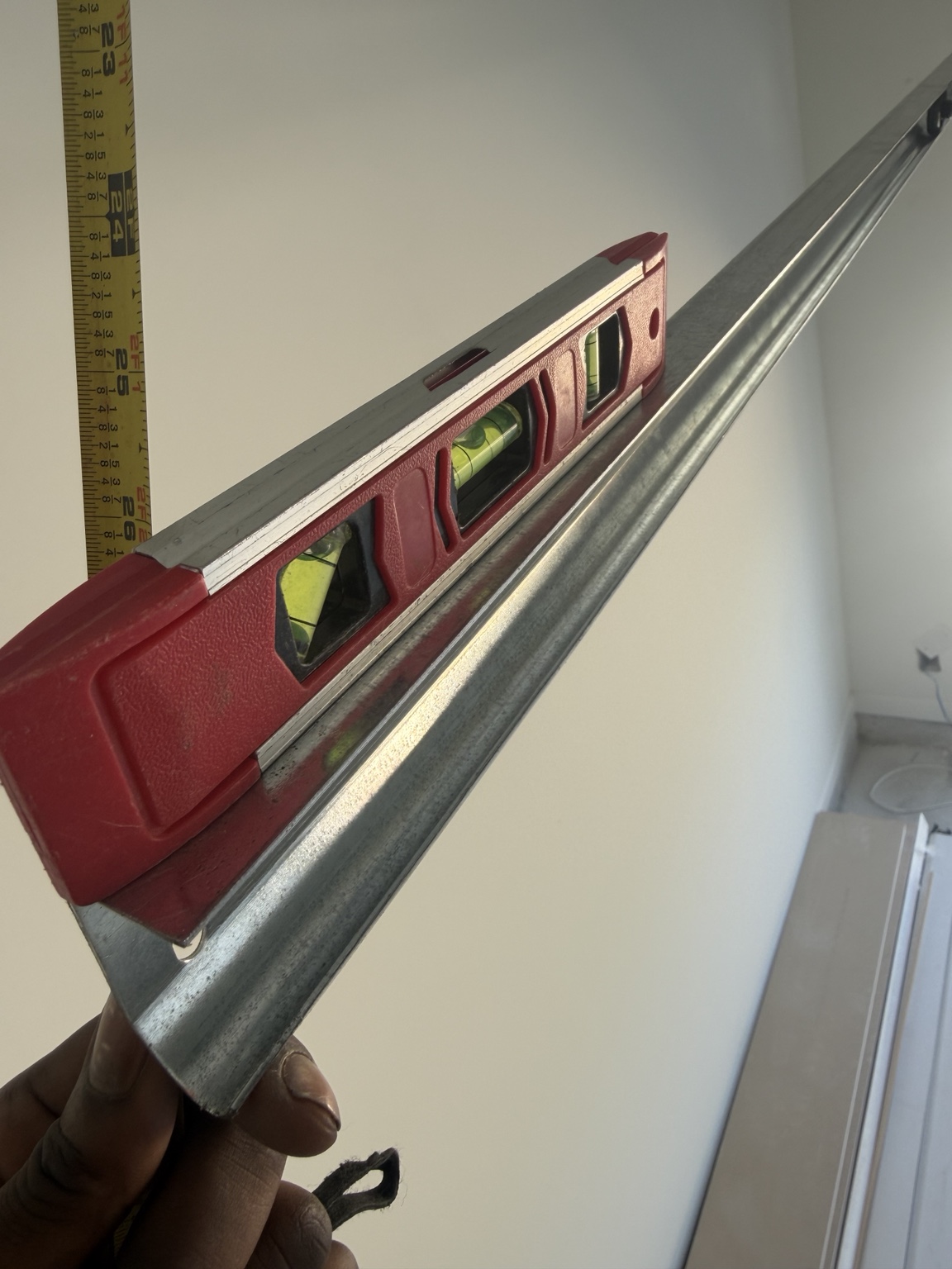 Level positioned on garage door track during precision installation